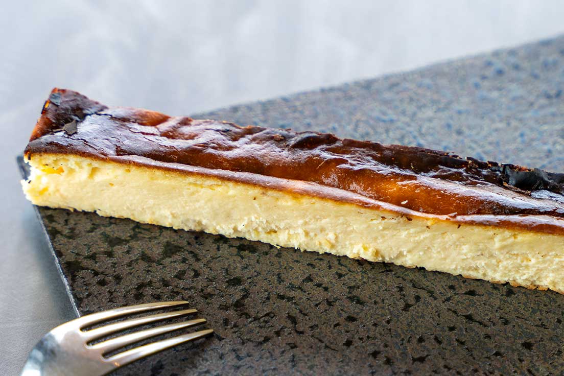 フェイマスニッチの手作りバスクチーズケーキ。香ばしく焼き上げた表面となめらかな食感が特長