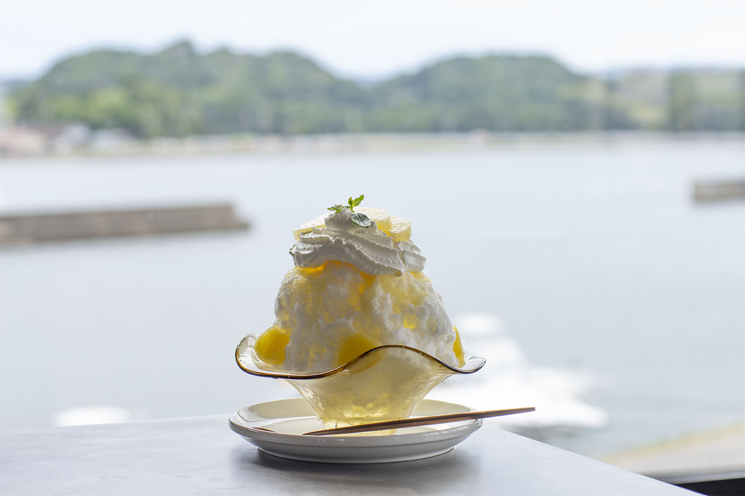 生クリームにパイナップルとミントを添えた、夏限定パイナップルかき氷を真上から見た写真